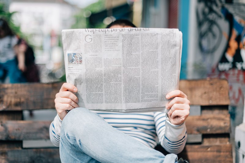 Person reading newspapers for research